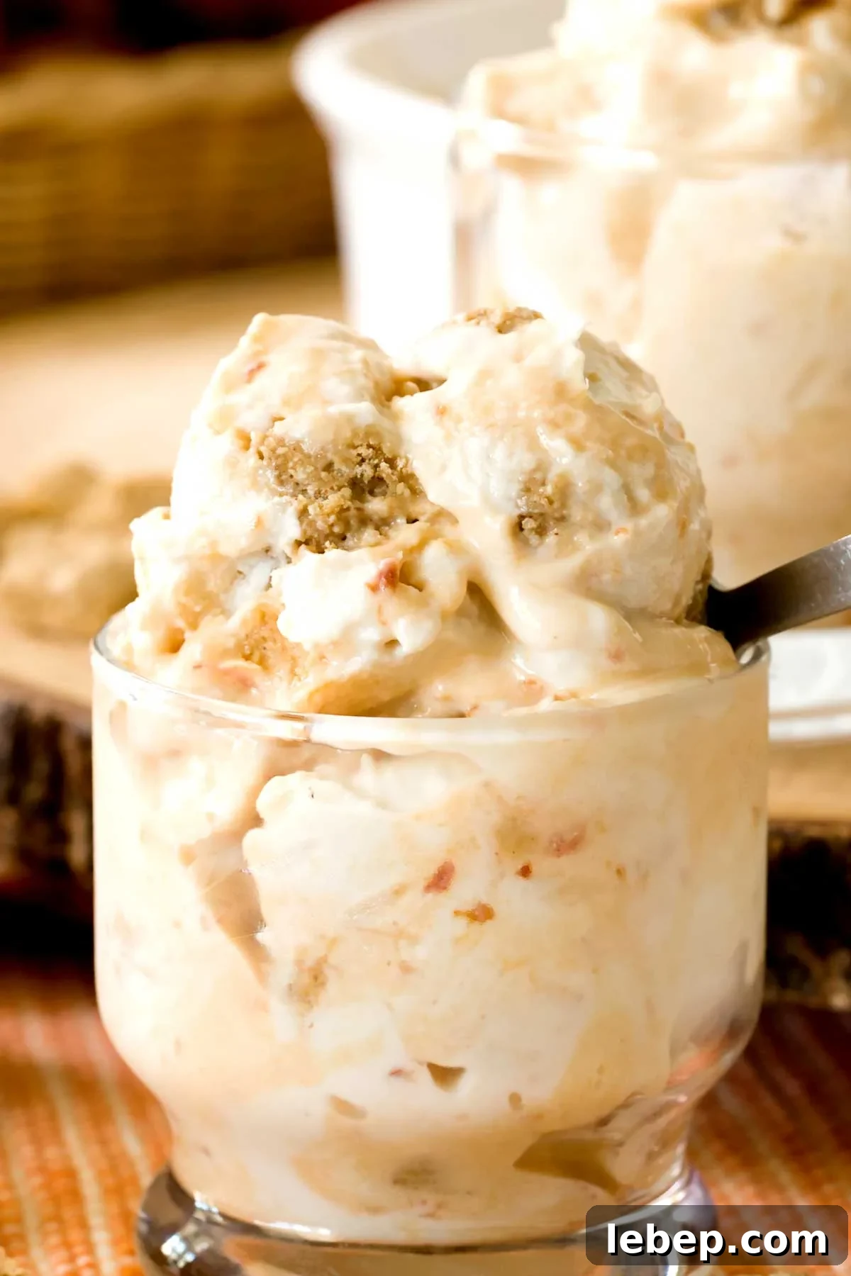 A close-up of peach pie cottage cheese ice cream in a small glass bowl with a spoon.