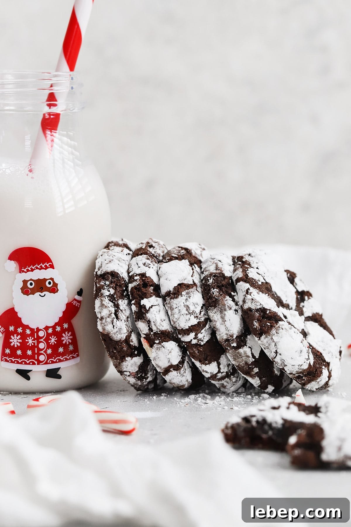 Gluten-Free Peppermint Chocolate Crinkle Cookies Recipe 3 Front view of a stack of gluten-free peppermint chocolate crinkle cookies leaning on a bottle of milk