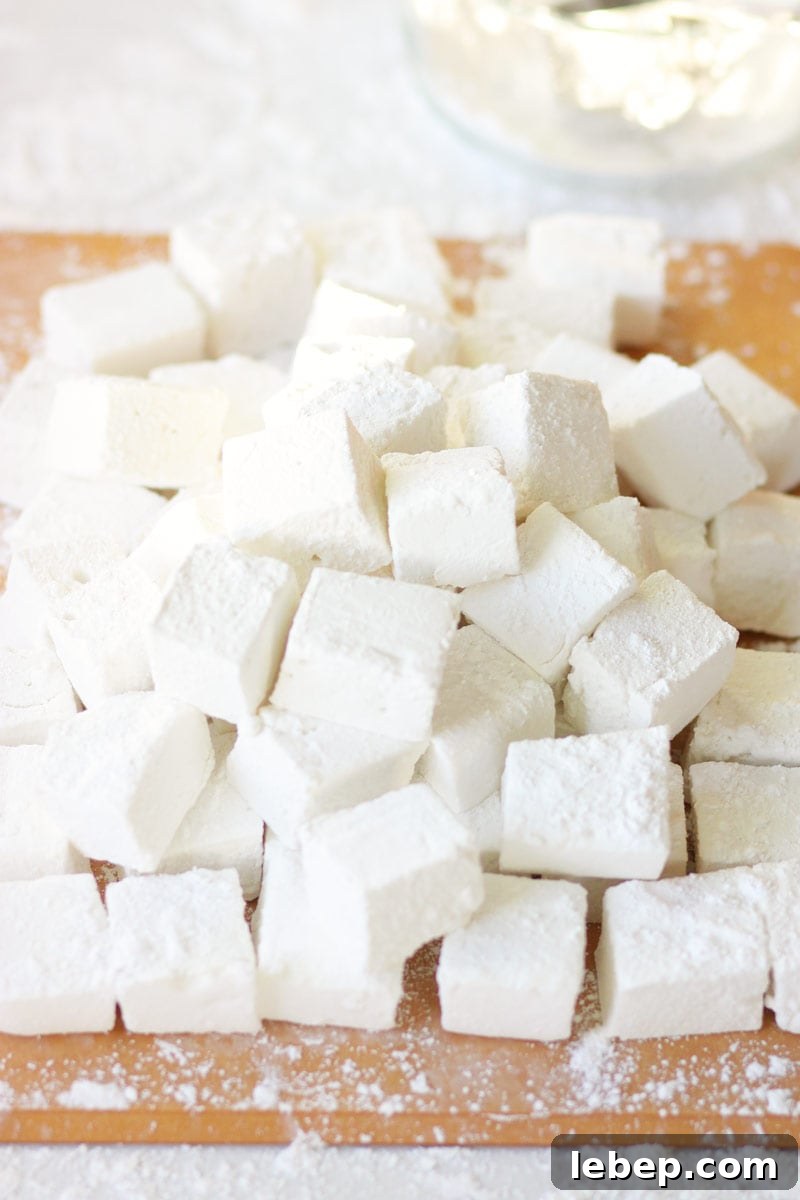 Homemade Marshmallows Without Corn Syrup: Simple Recipe 2 homemade marshmallows in a pile on a cutting board