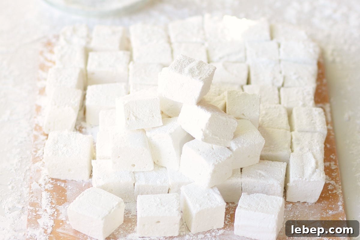 Homemade Marshmallows Without Corn Syrup: Simple Recipe 7 homemade marshmallows in a pile on a cutting board