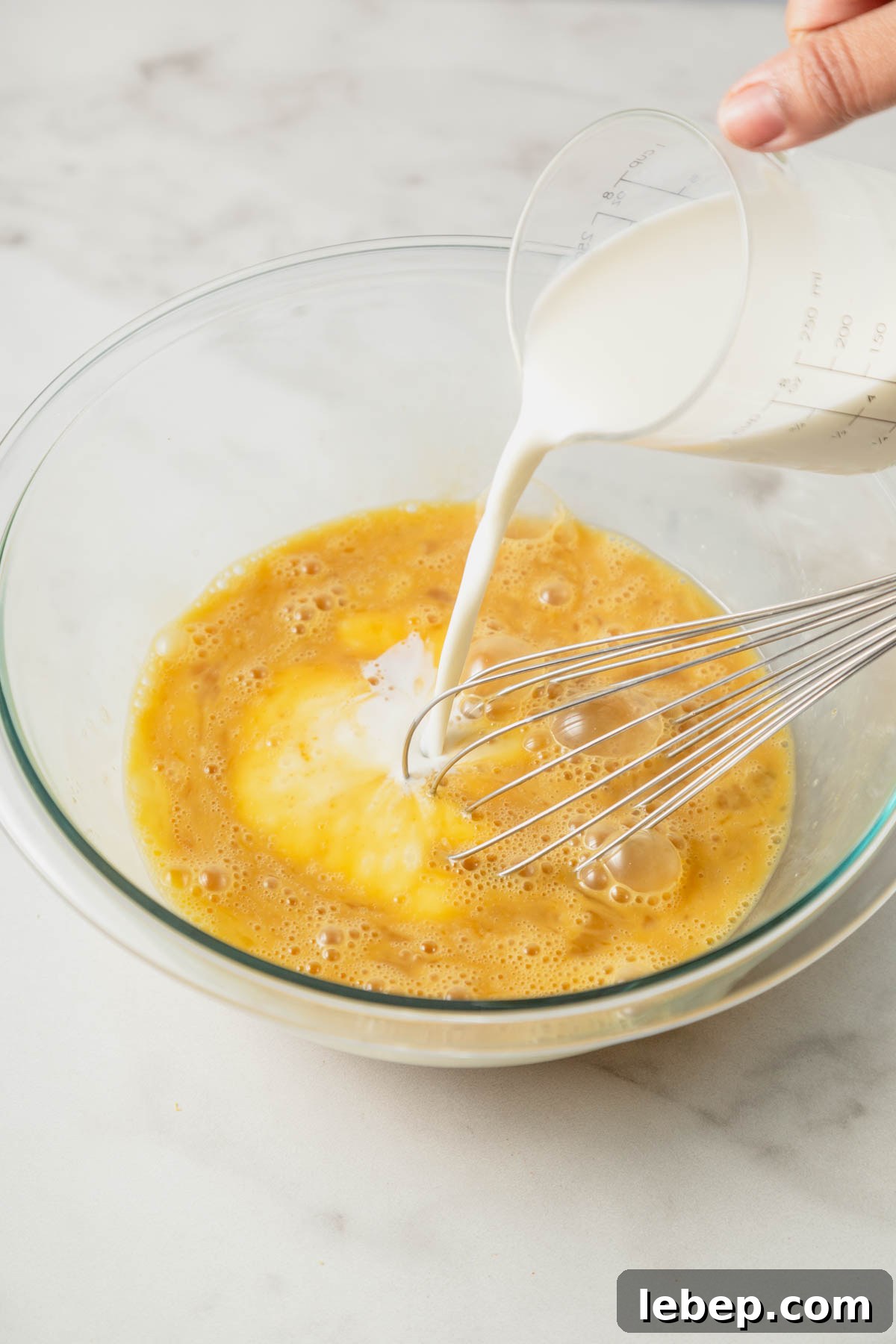 Brioche French Toast Casserole Recipe for Brunch or Holidays 6 adding milk to the egg mixture.
