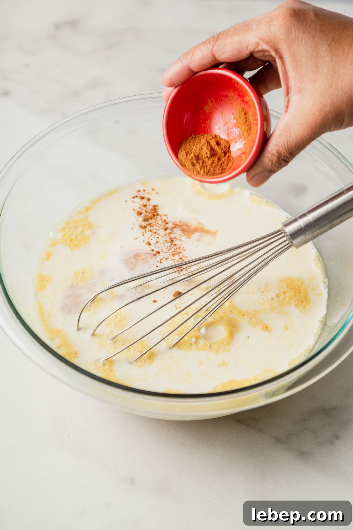 Brioche French Toast Casserole Recipe for Brunch or Holidays 7 adding spices to the egg mixture.