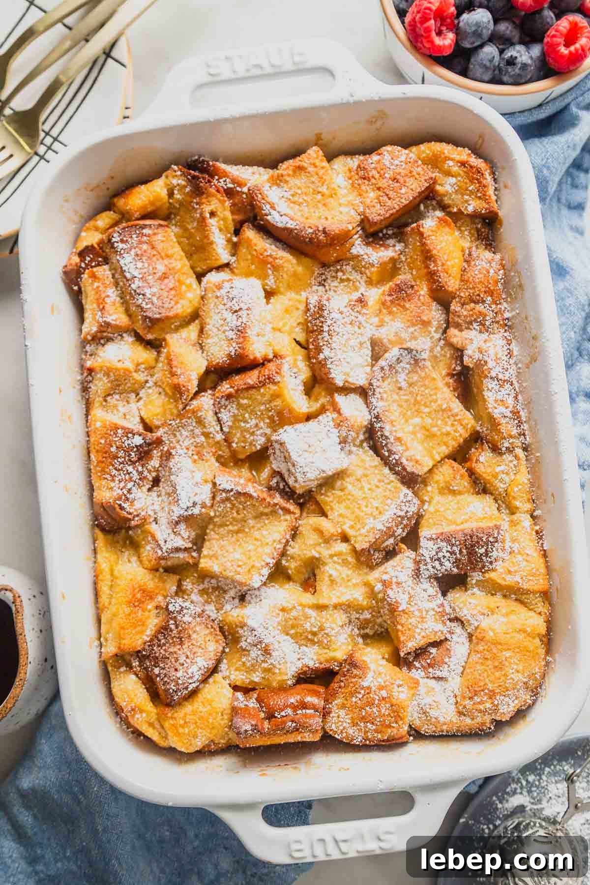 Brioche French Toast Casserole Recipe for Brunch or Holidays 10 brioche french toast casserole with maple syrup and berries on the side.