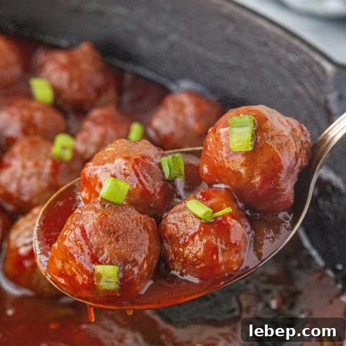 Cranberry sauce meatballs in an iron skillet.