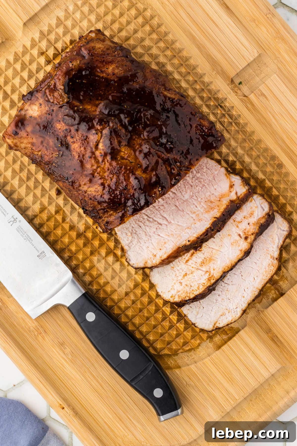 Overhead view of the pork loin sliced on a cutting board with a knife next to it.