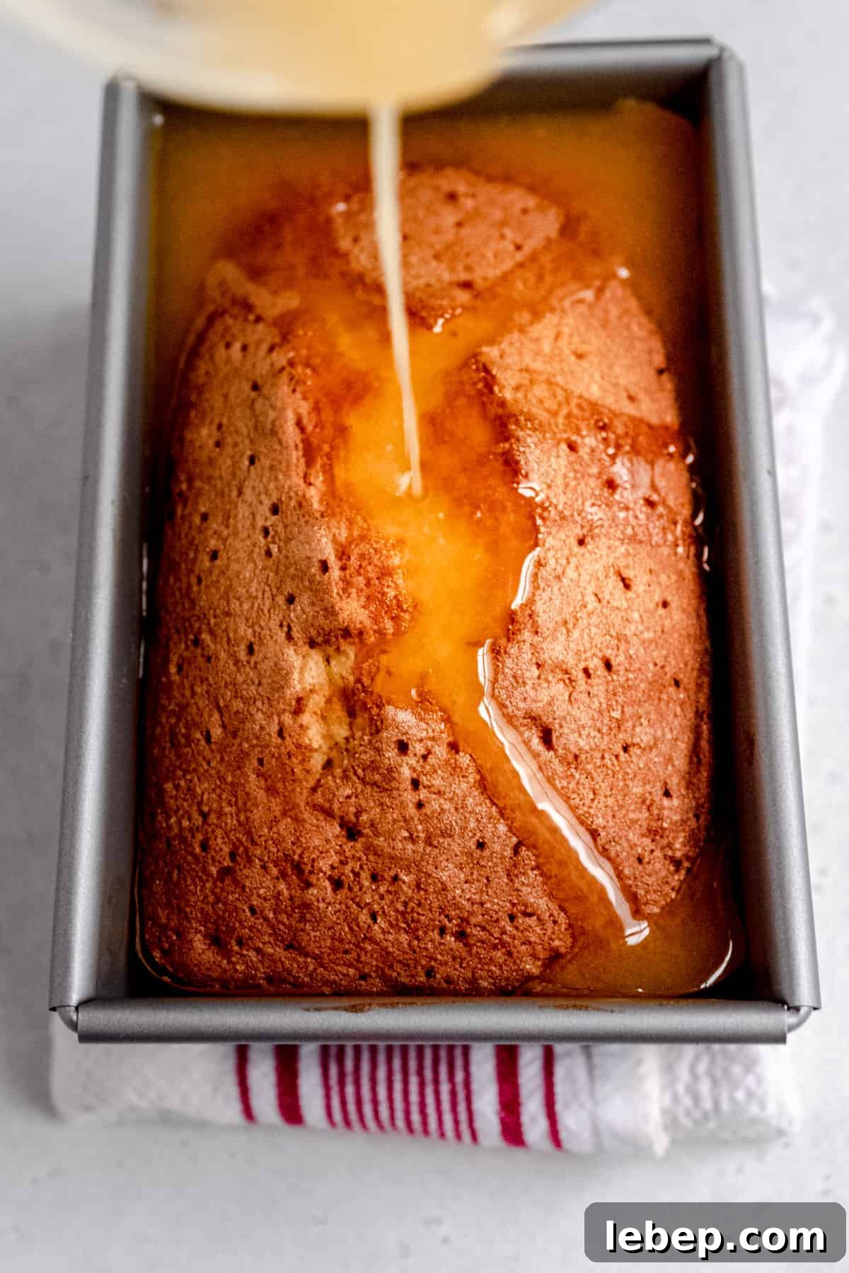 Orange Drizzle Cake Recipe with Zesty Glaze 7 orange drizzle cake with the soaking syrup being added