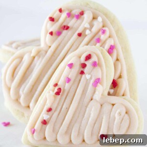 Heart shaped sugar cookies with strawberry buttercream and mini heart sprinkles.