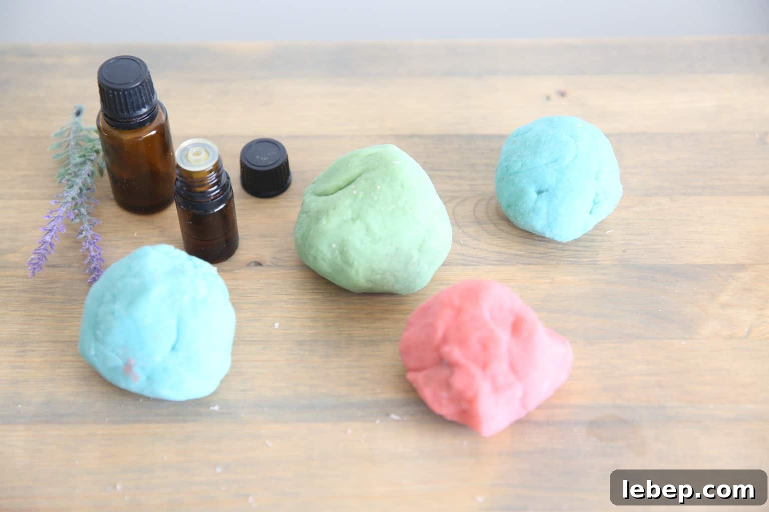 Aromatic Homemade Play Dough Recipe for Calming Sensory Play 2 4 different colored balls of fresh made playdough on wooden table top