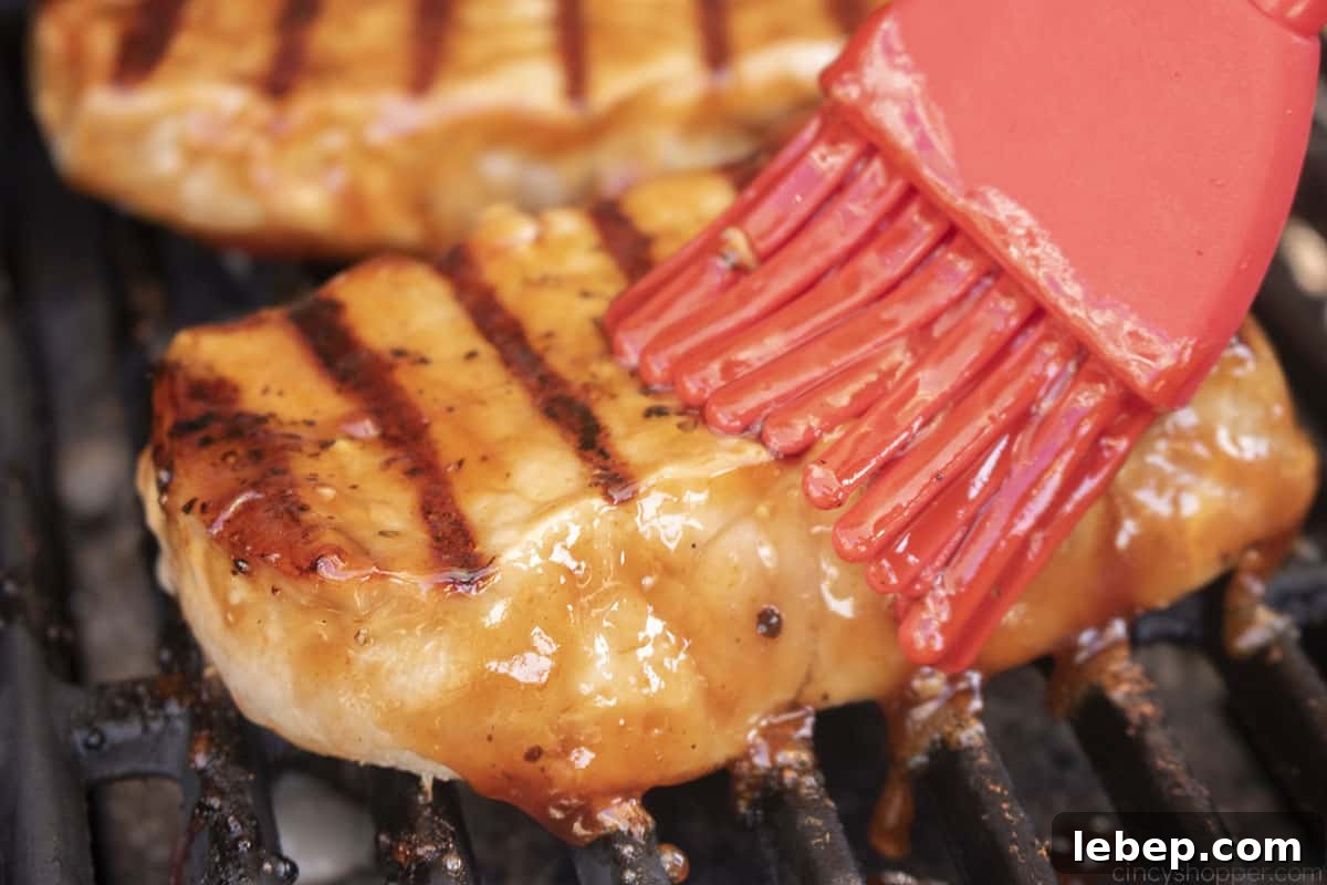 Brushing BBQ sauce on pork chops.