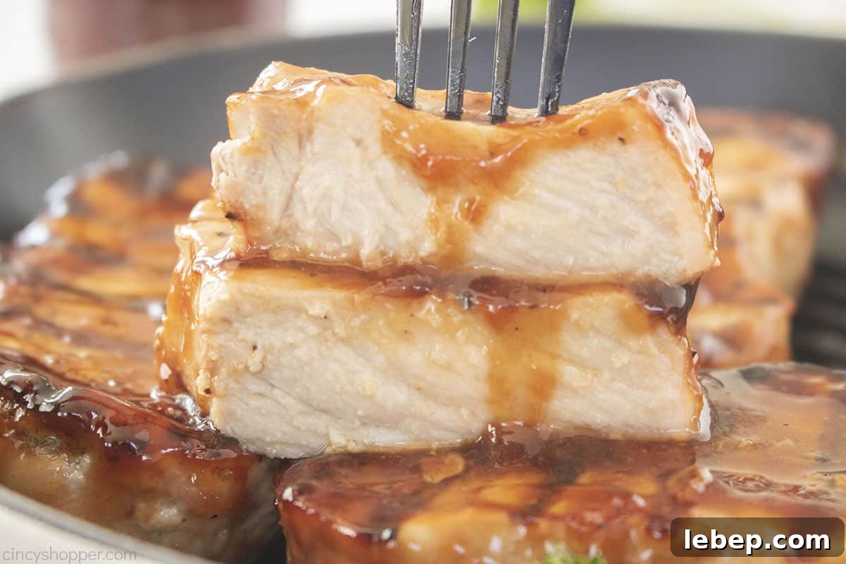 Juicy Pork Chops on a fork with BBQ sauce.