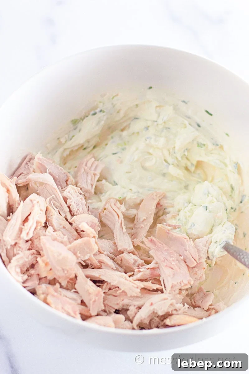 Cheesy Chicken Crescent Bake with Puff Pastry Squares 7 shredded chicken in a bowl with a cream cheese mixture