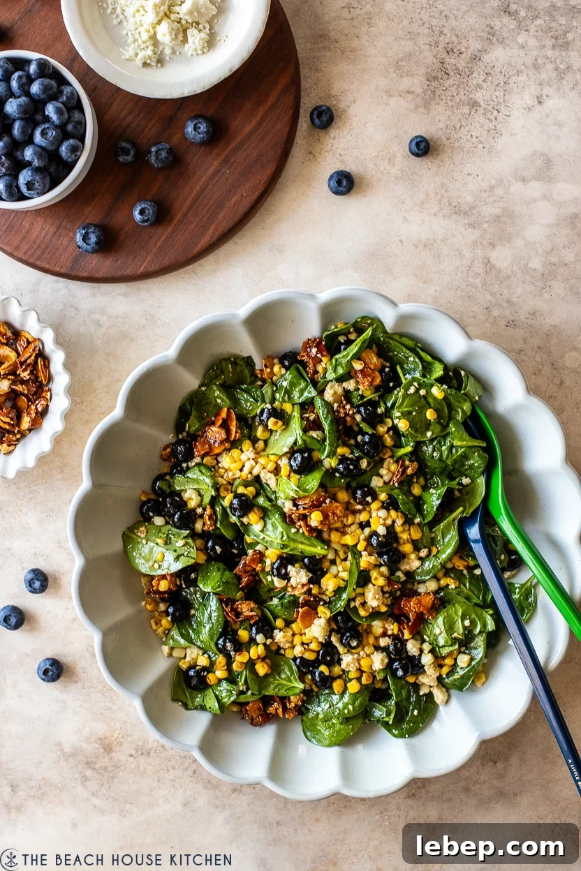 Overhead photo of a white scalloped platter filled with a blueberry corn salad