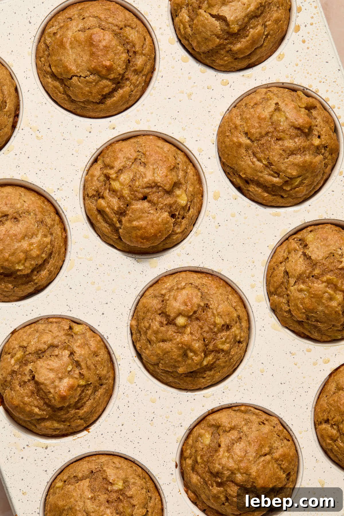 Spelt Flour Peanut Butter Banana Muffins — Naturally Sweetened 9 Muffins baked in a white muffin pan.
