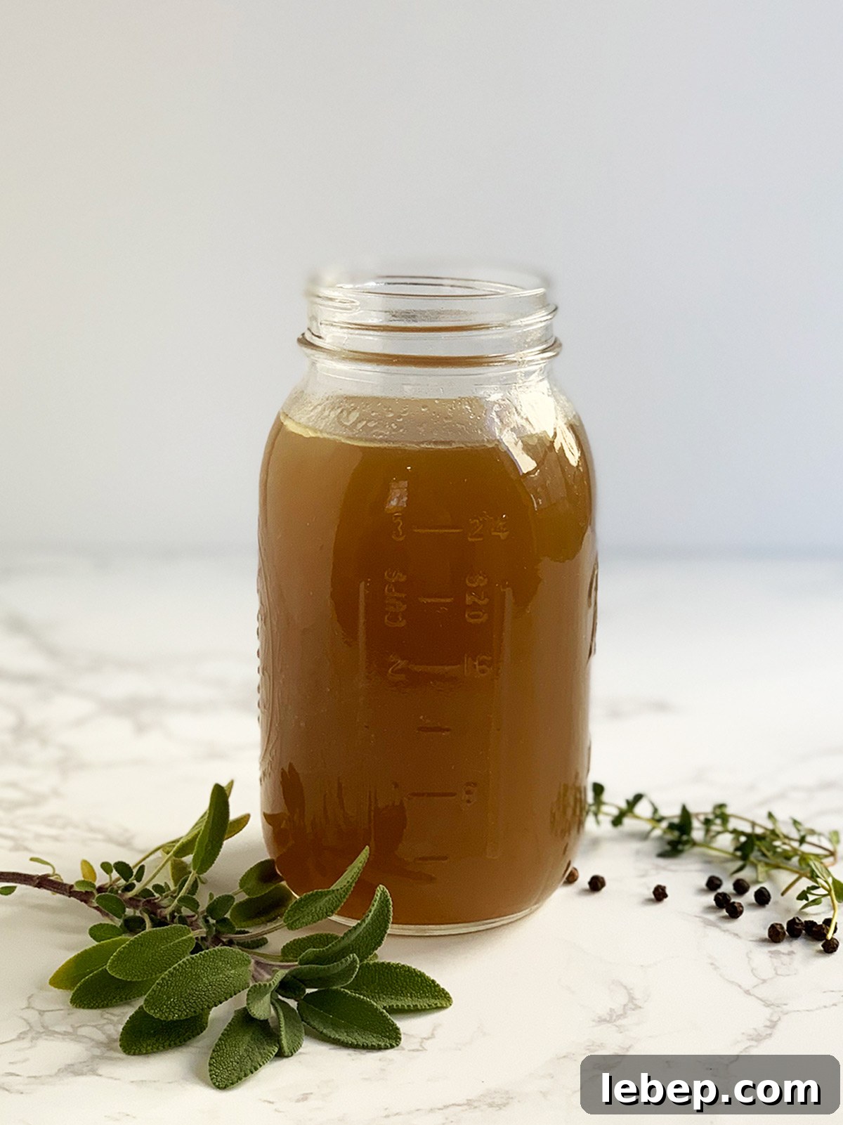 Sage Sausage Stuffing Recipe for Thanksgiving and Holiday Dinners 4 Turkey stock in glass jar with thyme, sage and peppercorns.