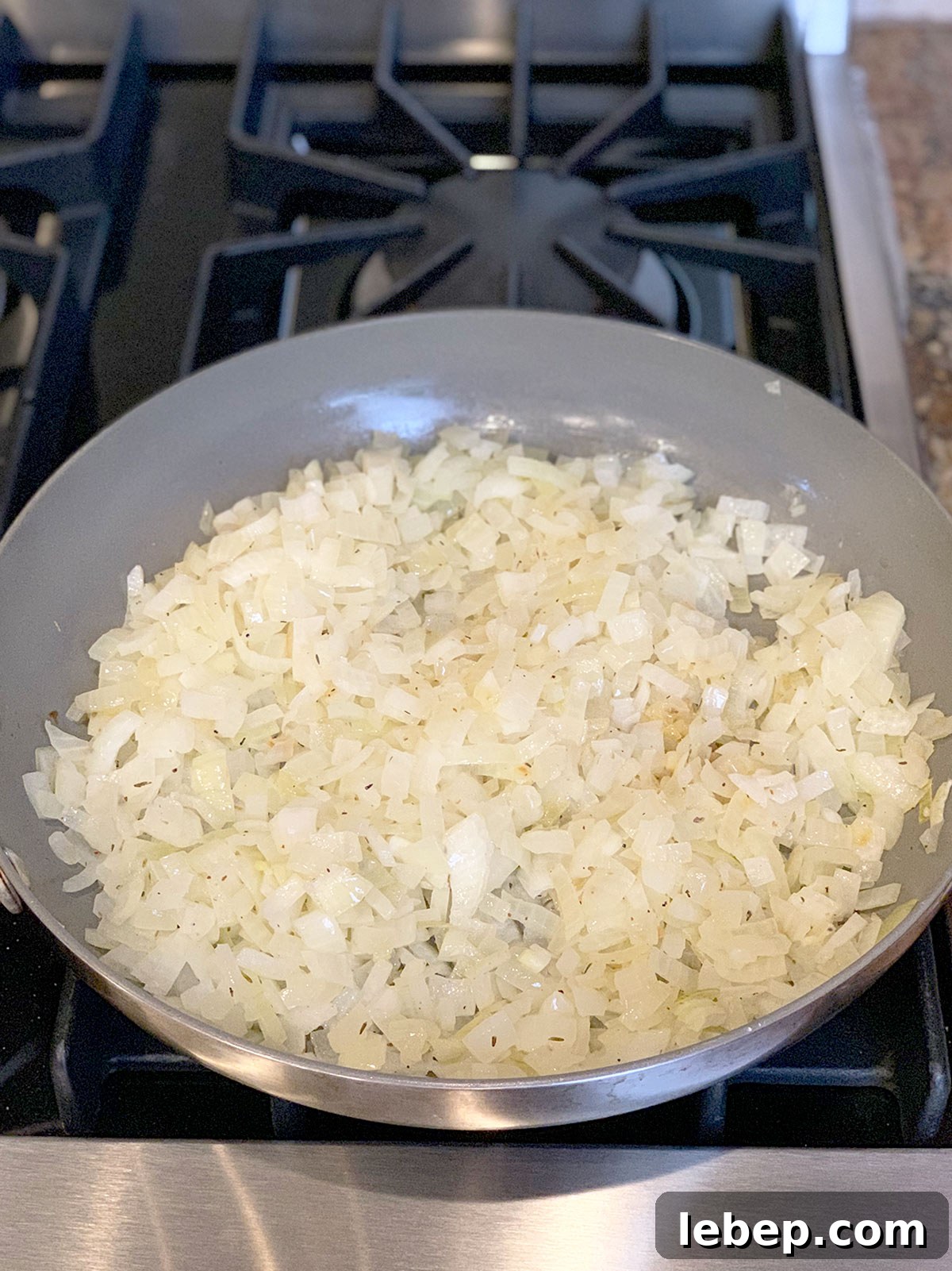 Sage Sausage Stuffing Recipe for Thanksgiving and Holiday Dinners 8 Sauteed onions in frying pan on stove top.