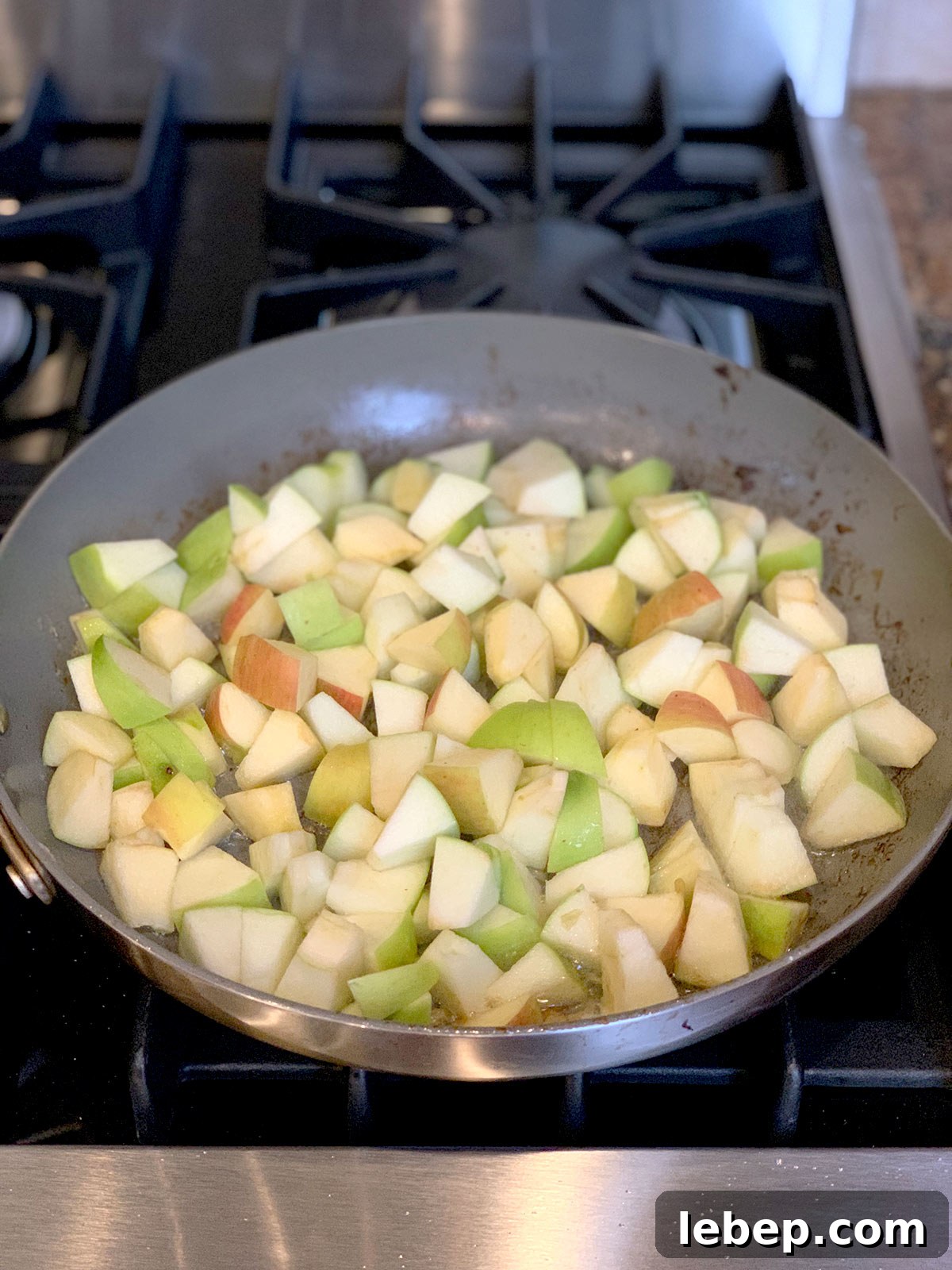 Sage Sausage Stuffing Recipe for Thanksgiving and Holiday Dinners 9 Sauteed apples in pan on stove top.